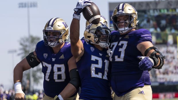 Wayne Taulapapa celebrates his Husky touchdown with Matteo Mele (78) and Roger Rosengarten (73).
